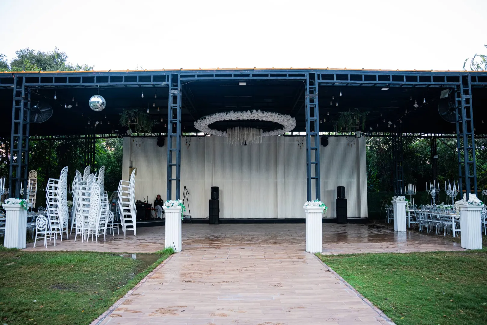 Hanedan Park bahçesinde sahne ve beyaz sandalyelerle hazırlanmış davet alanı